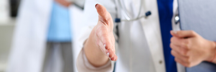 Female medicine doctor hold pad and give arm to shake