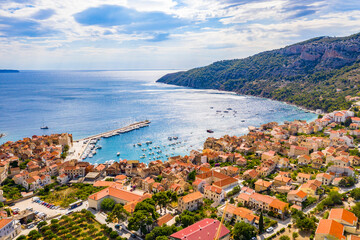Fototapeta na wymiar Aerial panoramic view of city Komiza - the one of numerous port towns in Croatia, is a lot of moored sailboats of a regatta