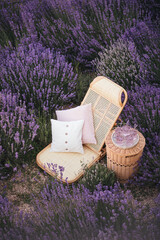 Wicker chair and table with fresh homemade lemonade in lavender field.
