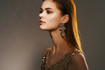 cheerful woman in a golden dress jewelry earrings fashion glamor