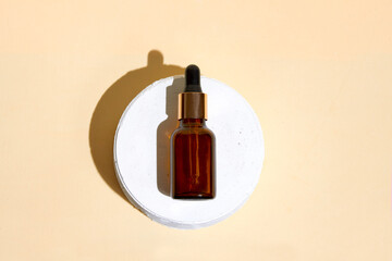 Cosmetics bottle with dropper staying on the pastel beige background. 
Earth colors, zero waste containers. Mockup concept. Minimal boxes and geometric podium. Scene with geometrical forms. 
