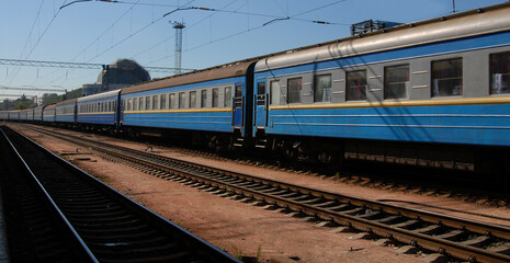Fototapeta premium Exterior of blue train with sleeping wagons, departing from railway station. Railroad travel and transportation concept.