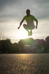 Fototapeta na wymiar At sunset a sporty man in sneakers starts his morning run
