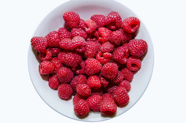 raspberries in a bowl on a white background, background with raspberries, freshly picked raspberries