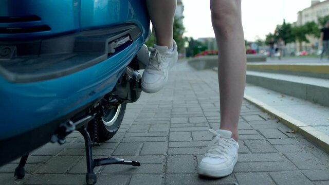 Girl starts the engine of motorbike with foot start rod or Kick starter