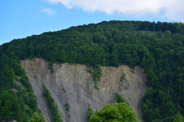 A cut of a large rock with multiple horizontal lines in the stone from erosion and weathering