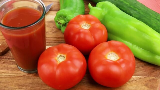 verre de jus de l&eacute;gumes et l&eacute;gumes frais sur une table