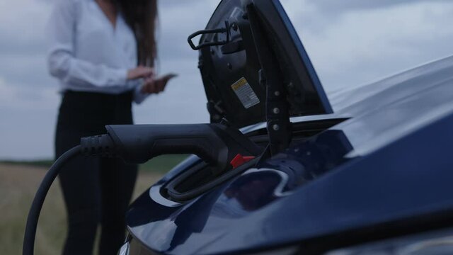 View of a charging electic car on the road