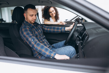 Young family choosing a car in a car showroom