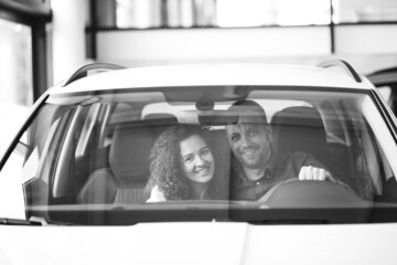 Young family buying a car in a car showroom
