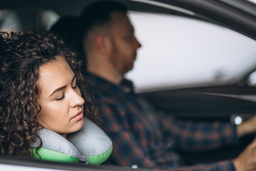 Woman sleeping in a car on a car pillow