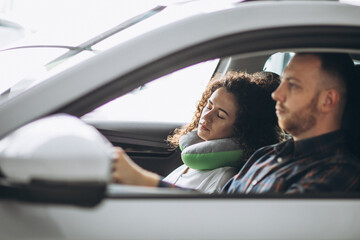 Woman sleeping in a car on a car pillow