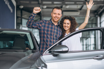 Young family buying a car in a car showroom
