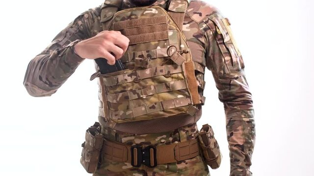 Man in body armor inserts rifle magazines