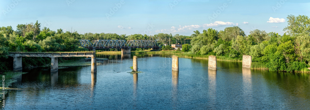 Wall mural Ancient ruined stone bridge and serene river