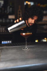 Mixologist pouring cocktail in bar