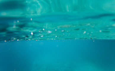 Naklejka na ściany i meble blue colored clear underwater surface texture with ripples splashes and bubbles
