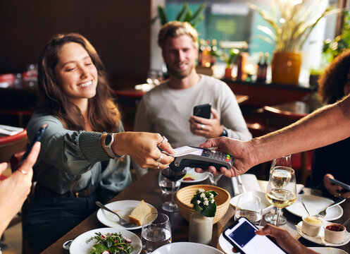 Woman Paying With Card In Restaurant