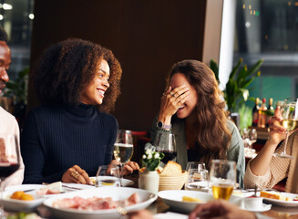 Friends telling jokes at dinner in restaurant