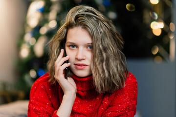 Beautiful young woman celebrating christmas at home, having fun while opening presents