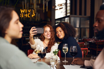 Friends taking selfie in wine bar
