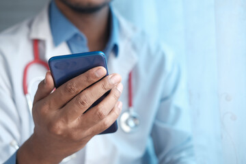 doctor in white coat using a smartphone.