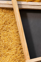 Raw pasta in asymmetrical boxes, space for text