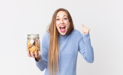 thin pretty woman shouting aggressively with an angry expression and holding a cookies