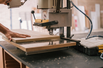 Man baking a wooden panel with an industrial machine
