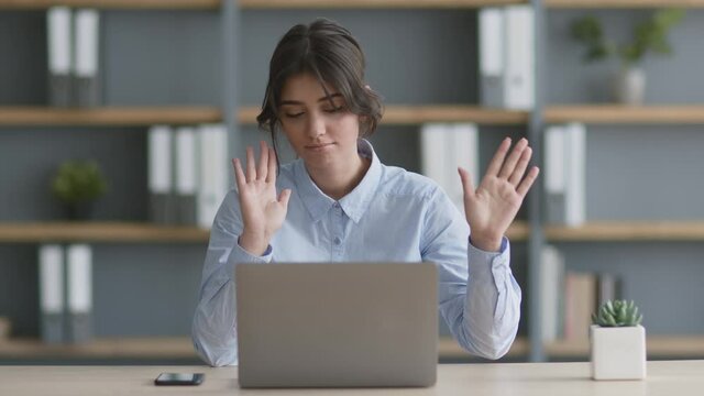 Finally vacation time. Young happy woman manager dancing at workplace, closing laptop and enjoying free time at office
