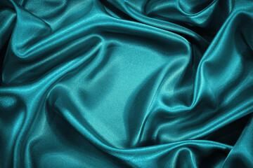 Beautiful blue green silk satin background. Wavy soft folds. Luxurious silky fabric backdrop with...