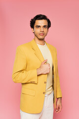 young man in trendy yellow blazer posing isolated on pink