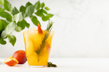 Recipe of cooking healthy summer peach juice - cocktail with ice, rosemary twig, sugar rim in glass...
