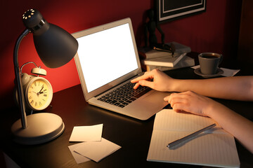 Woman working with laptop in office at night
