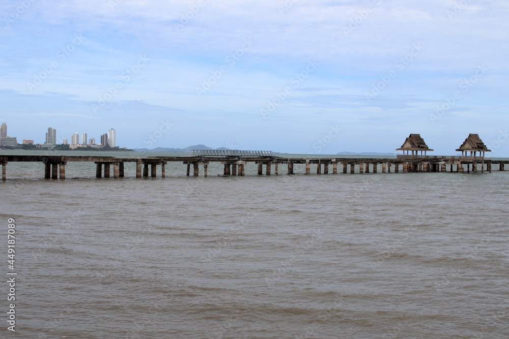 Wall mural a bridge, jetty or pier made of steel concrete, which leads to a deserted place right by the sea