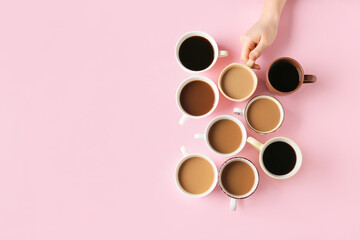 Female hand and cups of coffee on color background