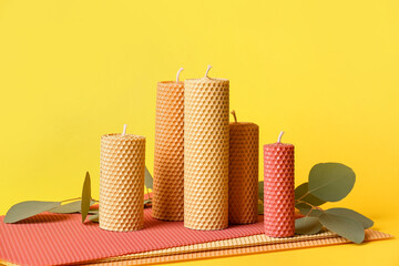 Handmade wax candles on color background