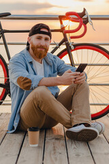 handsome bearded man traveling with bicycle in morning sunrise by the sea