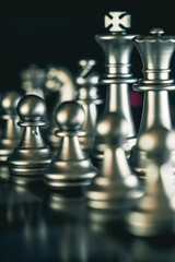 Vertical closeup shot of an arranged chessboard with metallic silver pieces
