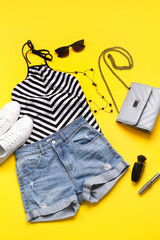 Female clothes, shoes and accessories on color background