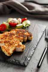chicken schnitzel with vegetables salad on a slate board
