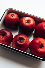 Many red ripe apples in a metal enamel container