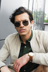 man in stylish sunglasses and bomber jacket looking at camera