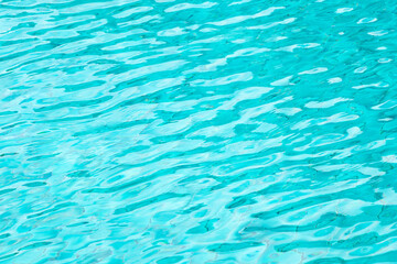Ripple Water in swimming pool with blue tile floor background