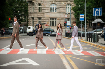 Four young students under umbrellas in the city