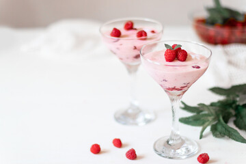 Delicious raspberry mousse with mint on a white table