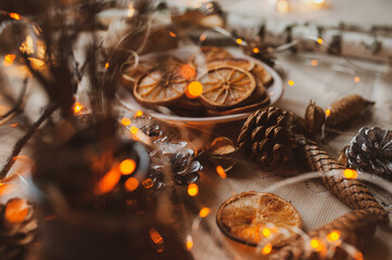 Fototapeta na wymiar Christmas New Year top view of handmade crafts with pine cones, dry round slices of oranges, garland, branches. New year holiday, celebration concept. Flatlay