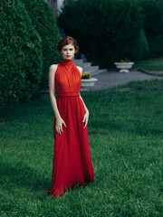 woman in red dress in garden nature charm fashion