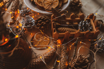 Christmas New Year top view of handmade crafts with pine cones, dry round slices of oranges, garland, branches. New year holiday, celebration concept. Flatlay