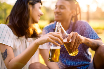 Cheerful couple toasting beer bottles